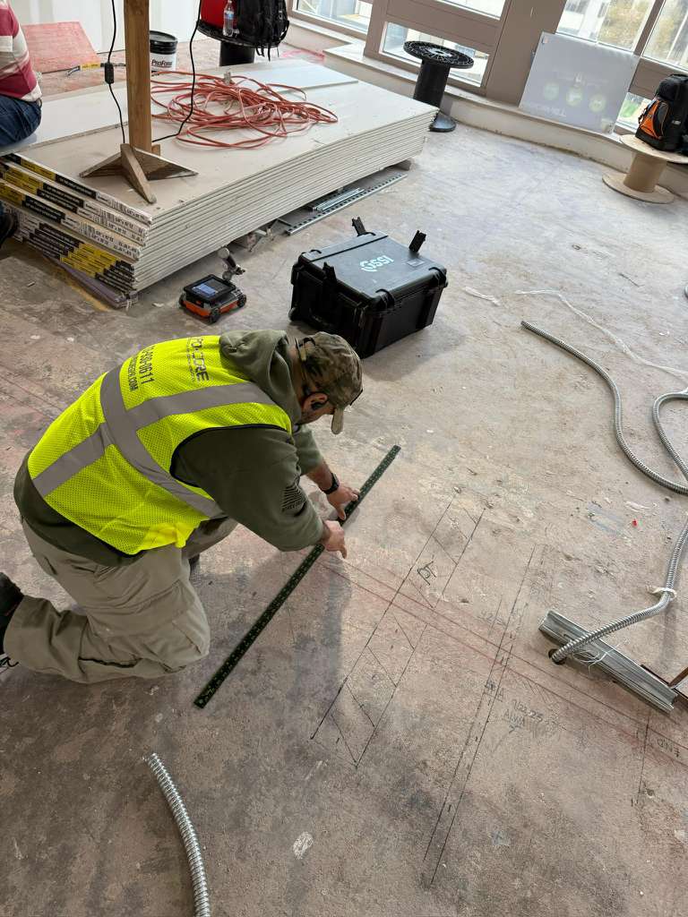 Technician marking concrete surface for coring