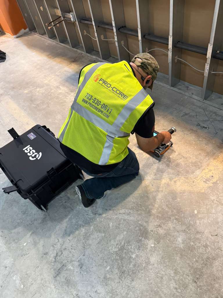Technician operating GPR scanning equipment on floor