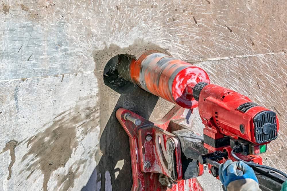 Technician performing concrete coring with professional equipment